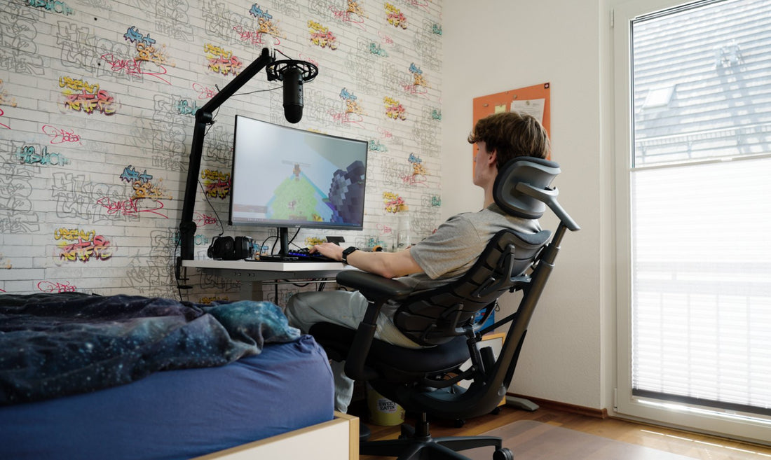 Student working at a desk in a LiberNovo dynamic ergonomic chair during a long study session